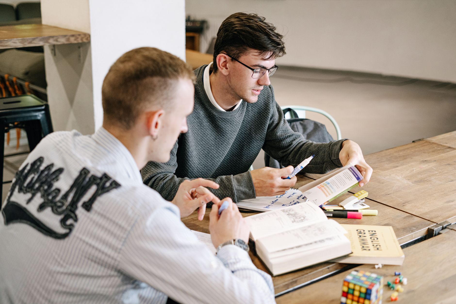 A student preparing for an English proficiency test at a desk with notes and headphones, illustrating the planning needed for IELTS or TOEFL.